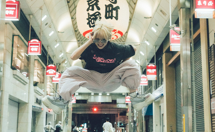 京都の商店街でジャンプしている様子。